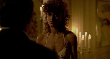 Movie still from “The King of Comedy” (1982), directed by Martin Scorsese – A woman in a white bra standing in front of candles; Close Up shot, Over the shoulder angle
