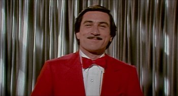Movie still from “The King of Comedy” (1982), directed by Martin Scorsese – A person wearing a suit and a bow tie; Close Up shot, Low angle