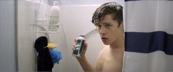 Movie still from “The Kings of Summer” (2013), directed by Jordan Vogt-Roberts – A young man is spraying himself with a can of beer; Close Up shot, Over the shoulder angle