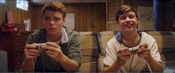 Movie still from “The Kings of Summer” (2013), directed by Jordan Vogt-Roberts – Two young men are sitting on a couch; Medium shot, Low angle