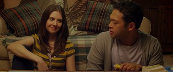 Movie still from “The Kings of Summer” (2013), directed by Jordan Vogt-Roberts – A man and a woman sitting next to each other on a couch; Close Up shot, Over the shoulder angle
