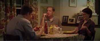 Movie still from “The Kings of Summer” (2013), directed by Jordan Vogt-Roberts – Two people sitting at a table eating hot dogs; Medium shot, High angle