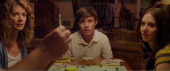 Movie still from “The Kings of Summer” (2013), directed by Jordan Vogt-Roberts – A young man sitting at a table with a board game in front of him; Close Up shot, Over the shoulder angle