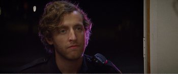 Movie still from “The Kings of Summer” (2013), directed by Jordan Vogt-Roberts – A person wearing a police uniform; Close Up shot, Over the shoulder angle