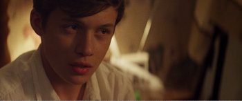 Movie still from “The Kings of Summer” (2013), directed by Jordan Vogt-Roberts – A person's face in the dark; Close Up shot, Over the shoulder angle