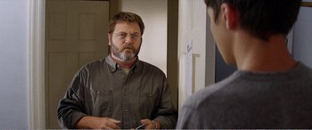 Movie still from “The Kings of Summer” (2013), directed by Jordan Vogt-Roberts – A man looking at himself in the mirror in front of a mirror; Medium shot, Over the shoulder angle