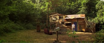 Movie still from “The Kings of Summer” (2013), directed by Jordan Vogt-Roberts – A man standing next to an old cabin in the woods; Extreme Wide shot, Low angle