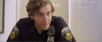 Movie still from “The Kings of Summer” (2013), directed by Jordan Vogt-Roberts – A man in a police uniform is talking into a microphone; Close Up shot, Over the shoulder angle