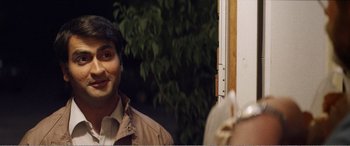 Movie still from “The Kings of Summer” (2013), directed by Jordan Vogt-Roberts – A man standing in front of a window with trees in the background; Close Up shot, Over the shoulder angle