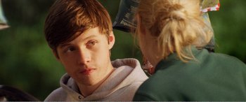 Movie still from “The Kings of Summer” (2013), directed by Jordan Vogt-Roberts – A young man is being brushed by a woman; Close Up shot, Over the shoulder angle