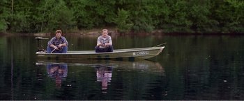 Movie still from “The Kings of Summer” (2013), directed by Jordan Vogt-Roberts – A man sitting in a boat on the water; Wide shot, High angle