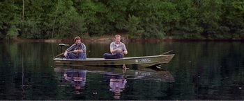 Movie still from “The Kings of Summer” (2013), directed by Jordan Vogt-Roberts – Two men are sitting in a boat on the water; Wide shot, High angle