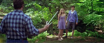Movie still from “The Kings of Summer” (2013), directed by Jordan Vogt-Roberts – A man holding a fork in front of two women; Medium shot, Over the shoulder angle