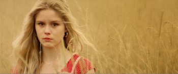 Movie still from “The Kings of Summer” (2013), directed by Jordan Vogt-Roberts – A woman in a red and white polka dot dress standing next to tall grass; Close Up shot, Low angle
