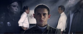 Movie still from “The Kings of Summer” (2013), directed by Jordan Vogt-Roberts – A young man is looking at the camera while standing in a room; Close Up shot, Low angle