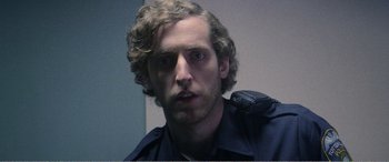 Movie still from “The Kings of Summer” (2013), directed by Jordan Vogt-Roberts – A person wearing a police uniform; Close Up shot, Low angle