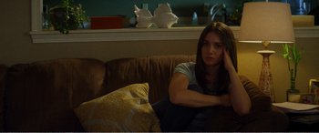 Movie still from “The Kings of Summer” (2013), directed by Jordan Vogt-Roberts – A woman sitting on a couch in a living room; Medium shot, High angle