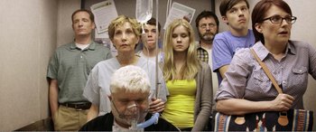 Movie still from “The Kings of Summer” (2013), directed by Jordan Vogt-Roberts – A group of people standing in a room; Medium shot, Over the shoulder angle