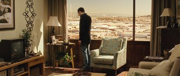 Movie still from “The Kite Runner” (2007), directed by Marc Forster – A man standing in front of a window looking out at a city; Wide shot, Over the shoulder angle