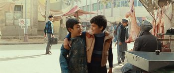 Movie still from “The Kite Runner” (2007), directed by Marc Forster – Two young boys standing next to each other on the street; Medium shot, Over the shoulder angle