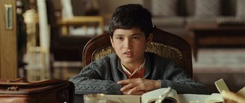 Movie still from “The Kite Runner” (2007), directed by Marc Forster – A boy sitting at a table reading a book; Close Up shot, High angle