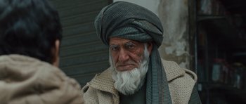 Movie still from “The Kite Runner” (2007), directed by Marc Forster – An old man with a long beard wearing a turban; Close Up shot, High angle