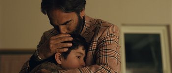 Movie still from “The Kite Runner” (2007), directed by Marc Forster – A man holding a young boy's head while he looks at the camera; Close Up shot, Over the shoulder angle