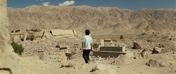 Movie still from “The Kite Runner” (2007), directed by Marc Forster – A young boy is walking through the ruins of a cemetery; Extreme Wide shot, High angle