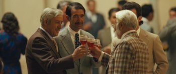 Movie still from “The Kite Runner” (2007), directed by Marc Forster – A group of men toasting with wine at a party; Medium shot, Over the shoulder angle
