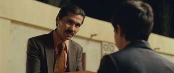 Movie still from “The Kite Runner” (2007), directed by Marc Forster – A man in a suit and tie talking to a woman; Close Up shot, Over the shoulder angle