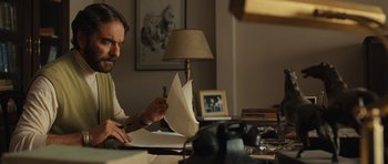 Movie still from “The Kite Runner” (2007), directed by Marc Forster – A man sitting at a table writing on a piece of paper; Medium shot, Low angle