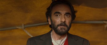 Movie still from “The Kite Runner” (2007), directed by Marc Forster – A person wearing a suit and beard; Close Up shot, Over the shoulder angle