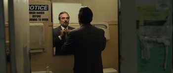 Movie still from “The Kite Runner” (2007), directed by Marc Forster – A man in a suit is looking at himself in the mirror; Medium shot, Over the shoulder angle