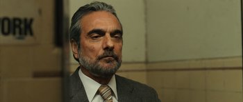 Movie still from “The Kite Runner” (2007), directed by Marc Forster – An older man in a suit and tie looking to his left; Close Up shot, Low angle