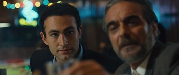 Movie still from “The Kite Runner” (2007), directed by Marc Forster – Two men sitting at a table with a glass of wine; Close Up shot, Over the shoulder angle