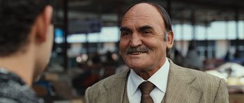 Movie still from “The Kite Runner” (2007), directed by Marc Forster – An older man wearing a suit and a tie; Close Up shot, Low angle