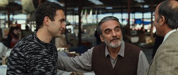 Movie still from “The Kite Runner” (2007), directed by Marc Forster – A man with a beard is talking to another man; Medium shot, Over the shoulder angle