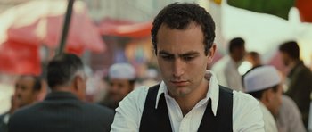Movie still from “The Kite Runner” (2007), directed by Marc Forster – A person wearing a white shirt and a black vest; Close Up shot, Over the shoulder angle