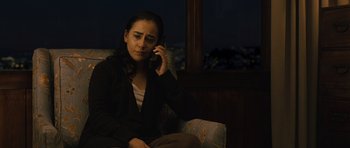 Movie still from “The Kite Runner” (2007), directed by Marc Forster – A woman sitting in a chair talking on a phone; Medium shot, High angle