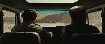 Movie still from “The Kite Runner” (2007), directed by Marc Forster – Two people are looking out the window of an airplane; Wide shot, Over the shoulder angle