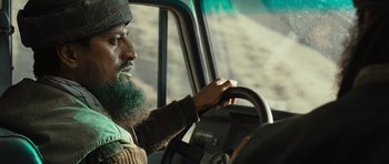 Movie still from “The Kite Runner” (2007), directed by Marc Forster – A bearded man driving a truck on the road; Close Up shot, Low angle