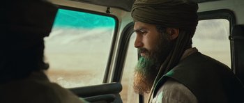 Movie still from “The Kite Runner” (2007), directed by Marc Forster – A man with a long beard driving a car; Close Up shot, Over the shoulder angle