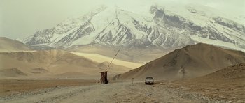 Movie still from “The Kite Runner” (2007), directed by Marc Forster – A car parked on the side of a road in the middle of a desert; Extreme Wide shot, Low angle