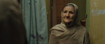 Movie still from “The Kite Runner” (2007), directed by Marc Forster – An old woman wearing a blanket and a head covering; Close Up shot, Over the shoulder angle