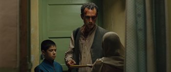 Movie still from “The Kite Runner” (2007), directed by Marc Forster – A man holding a knife with blood on his face; Medium shot, Over the shoulder angle