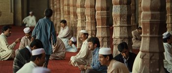 Movie still from “The Kite Runner” (2007), directed by Marc Forster – A group of men sitting next to each other on the ground; Wide shot, Over the shoulder angle