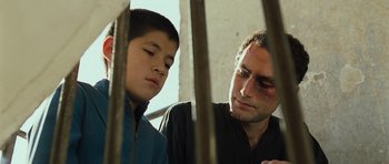 Movie still from “The Kite Runner” (2007), directed by Marc Forster – A man and a boy are sitting next to each other; Close Up shot, Low angle