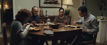 Movie still from “The Kite Runner” (2007), directed by Marc Forster – A group of people sitting around a table eating food; Medium shot, High angle