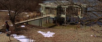 Movie still from “The Lake House” (2006), directed by Alejandro Agresti – An old house is sitting in the middle of a pond; Extreme Wide shot, High angle