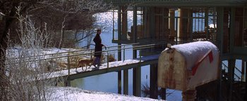 Movie still from “The Lake House” (2006), directed by Alejandro Agresti – A man and a dog walking across a bridge over a river; Wide shot, Low angle